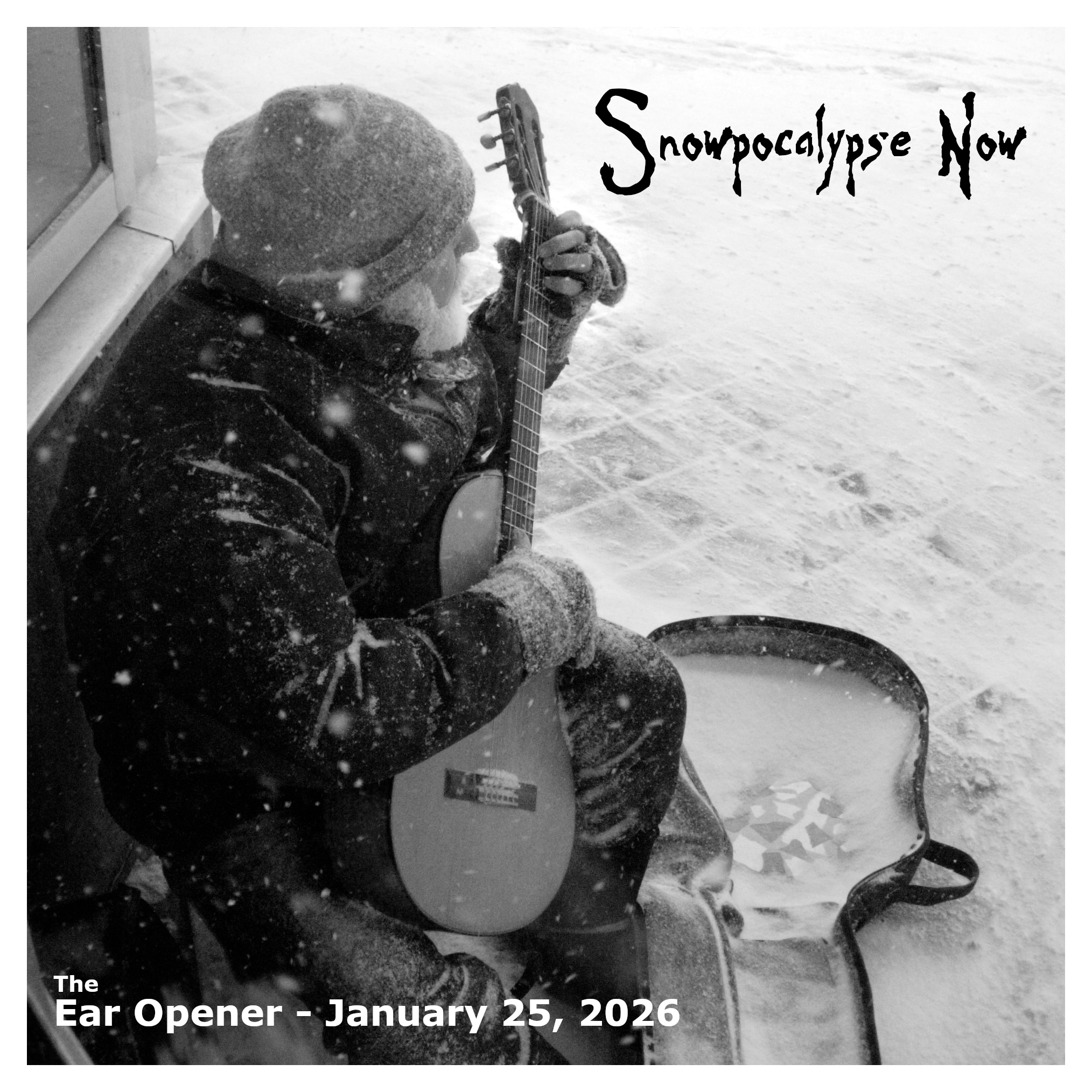A man playing an acoustic guitar in the snow.